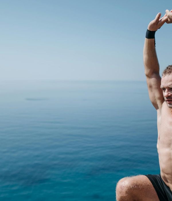 Person feeling energized and stretching outdoors with the sun in the background.